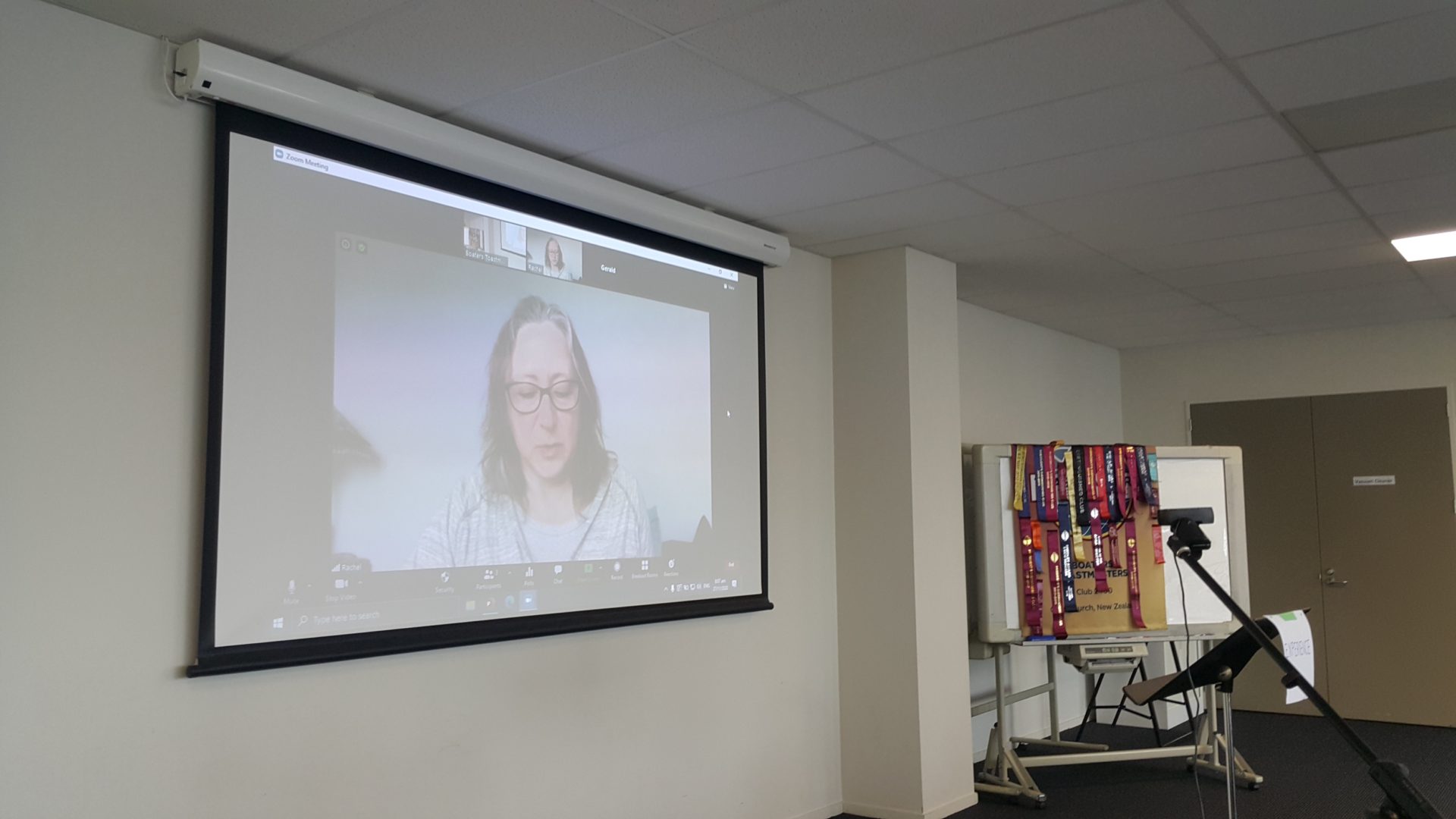 Woman projected speaking via Zoom on a screen