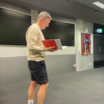 Man Standing holding Notebook